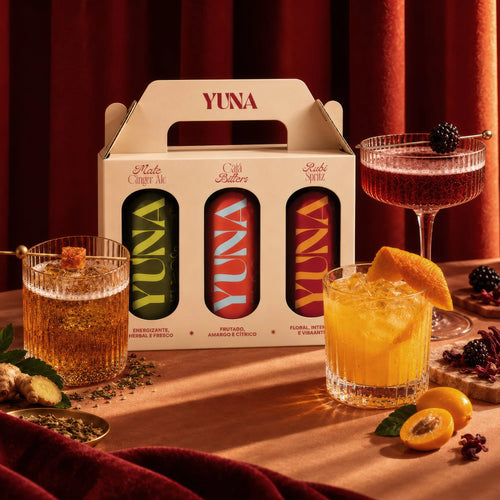 Kit Trio YUNA com latas e drinks servidos sobre mesa de madeira
