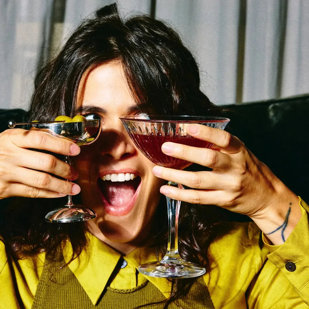 Mulher sorrindo segurando uma taça de drink